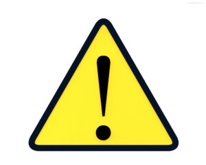 A picture of a caution sign to remind you to find out what to watch out for when vacationing